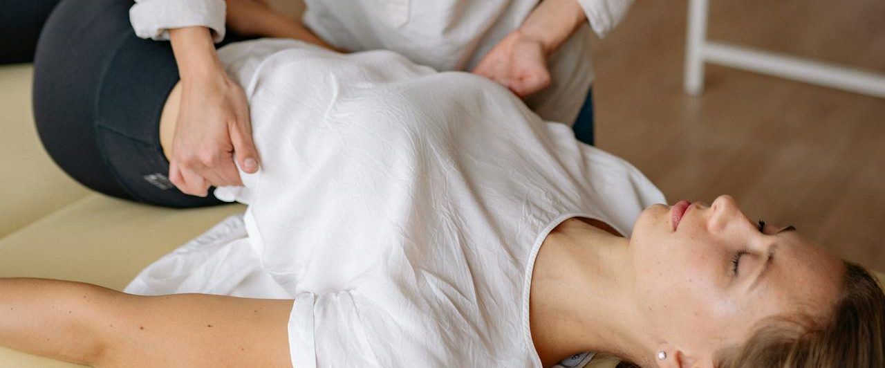 Eine Frau erhält eine manuelle Chiropraktik Behandlung auf einer Liege.