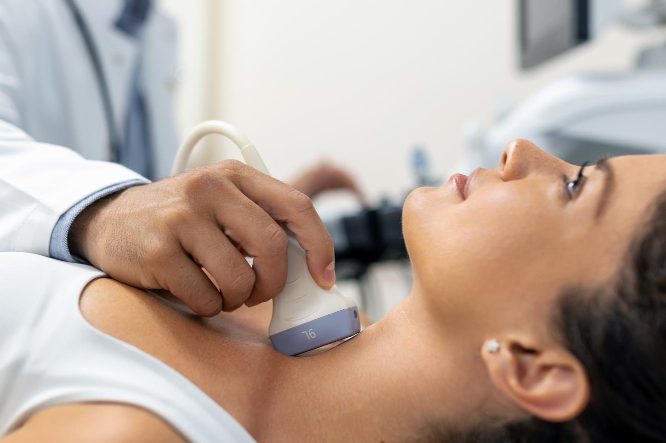 Ärztliche Untersuchung am Hals einer Patientin mit Ultraschallgerät.