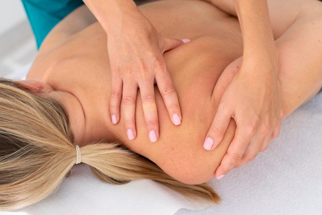 Massage einer Frau mit besonderem Fokus auf Schultern und Nacken.