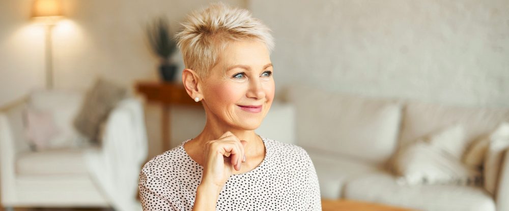 Eine Frau in den Wechseljahren lächelt.