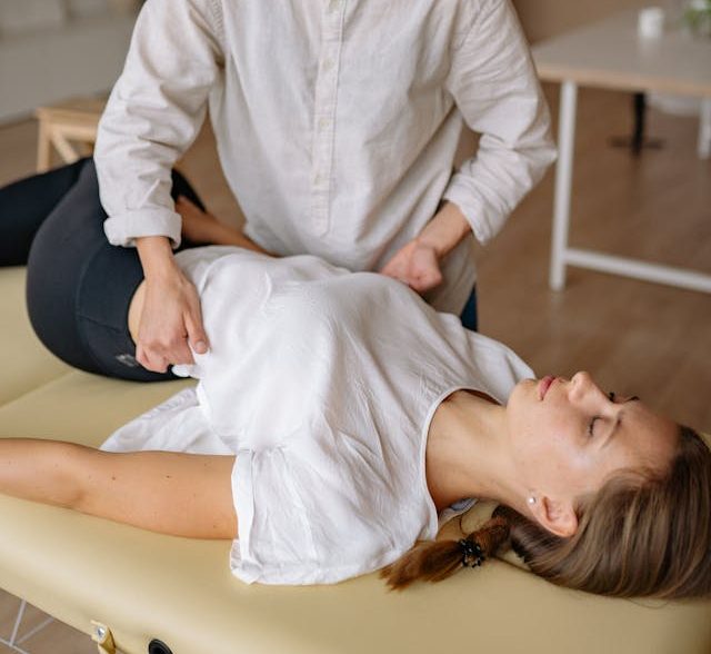 Eine Person erhält eine manuelle Therapie auf einer Liege.