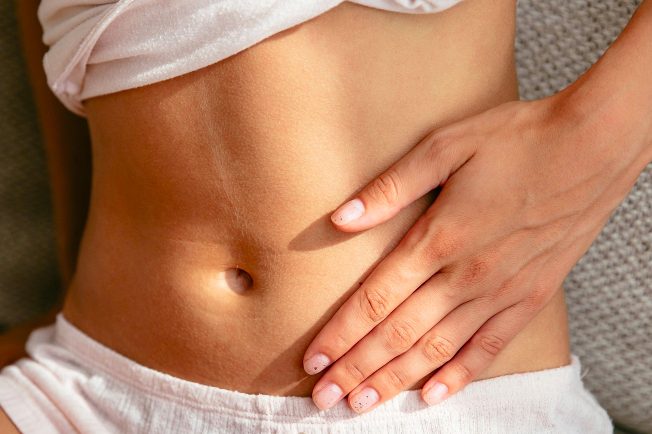 Eine Hand hält den Bauch.