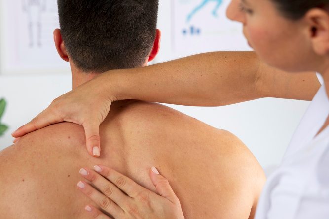 Eine Person liegt entspannt auf einer Liege, während eine andere Person sie behandelt.