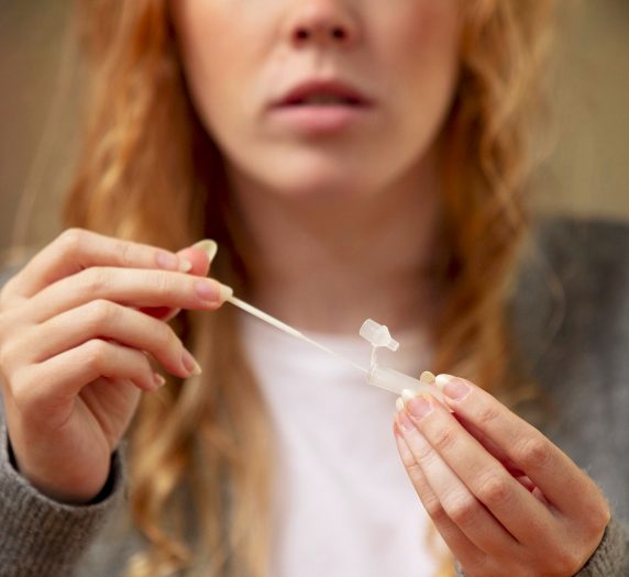 Eine Frau hält einen Teststab in der Hand, bereit für einen Test.