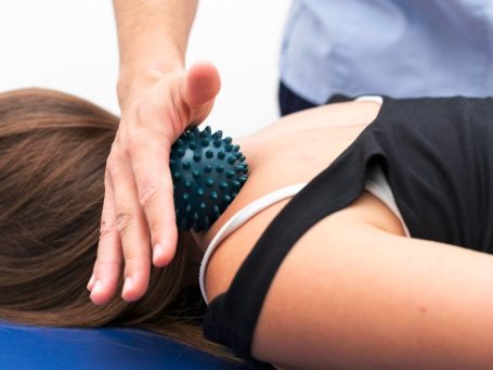 Die Heilpraktikerin prüft auf unterschiedliche Beinlängen auf einer Behandlungsliege.