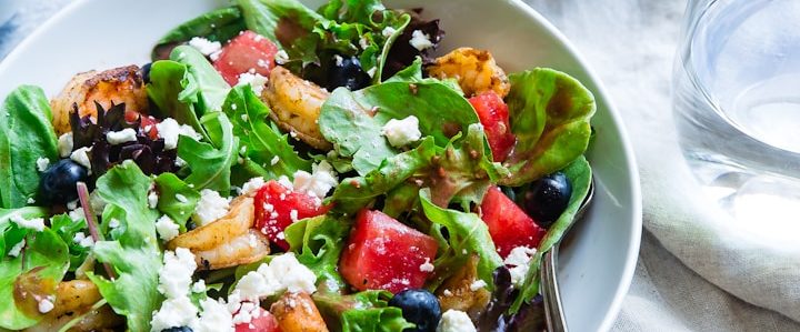 Frischer Salat mit verschiedenen Blattsalaten, Tomaten, Oliven und Feta.
